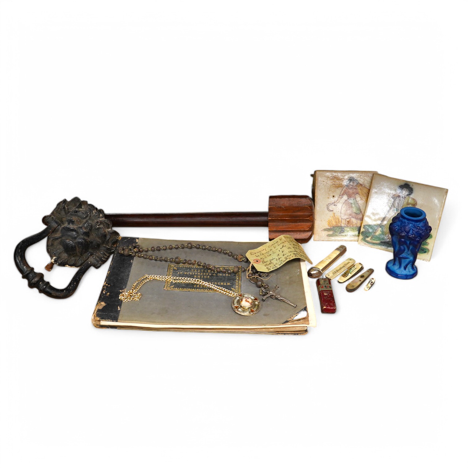 Miscellaneous items to include pen knives, a rosary bead necklace with paper label reading ‘said to have belonged to Mary Queen of Scots..’, a 19th century sketch book dated 1864 and lion head door knocker. Condition - v